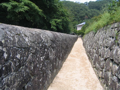 寮舎へ続く珍しい形の石垣屏。涼しい風が吹き抜けていく